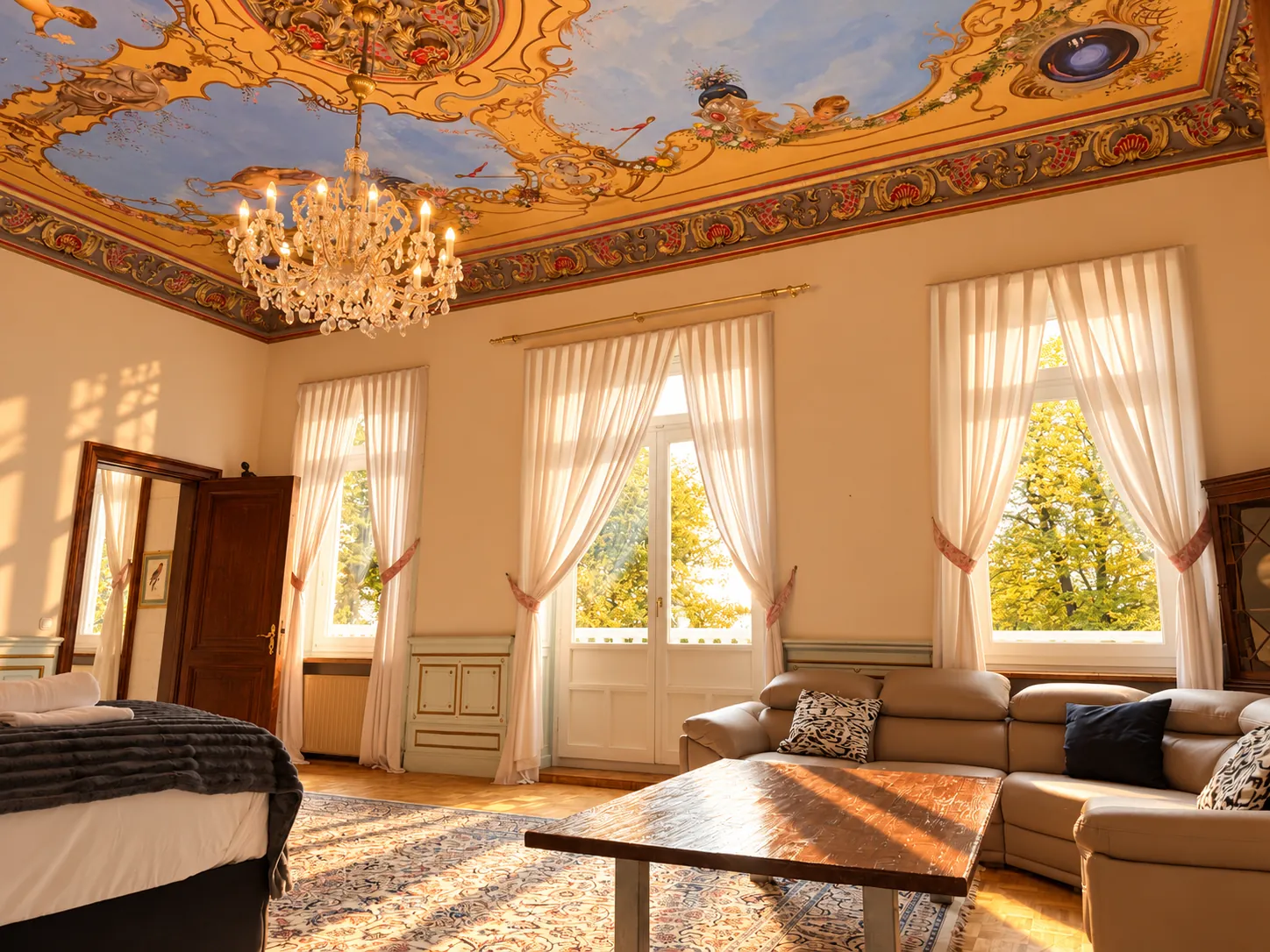 Suite mit bemalter Decke, Kronleuchter und hohen Fenstern